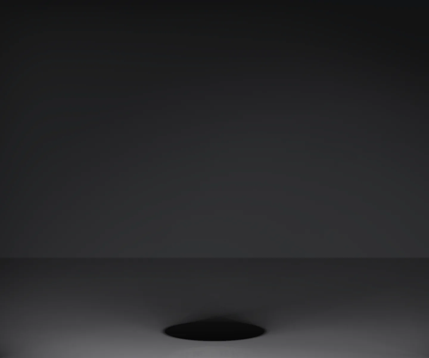 An empty charcoal-grey studio under one long soft light, a dark oval on its floor